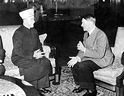 Abgebildet sind als Schwarz-Weiß-Fotografie Adolf Hitler und Amin el-Husseini, der Mufti von Jerusalem, beide sich auf Sesseln gegenüber sitzend, bei einem Zusammentreffen im November 1941 in der Reichskanzlei in Berlin.