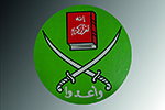 Abgebildet ist das Logo der Muslimbruderschaft. Auf einem kreisförmigen grünen Hintergrund befinden sich zwei übereinander gekreuzte Krummsäbel, über denen sich ein Buch mit rotem Einband befindet. Auf dem Bucheinband und unter dem Säbeln befinden sich arabische Schriftzeichen.